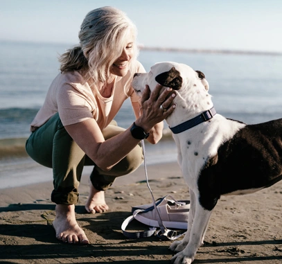 Photo of a woman with her dog at the beach